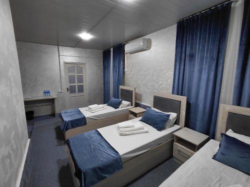 a room with three beds and a mirror at The Art Hotel by Art Hostel in Yakkasaray