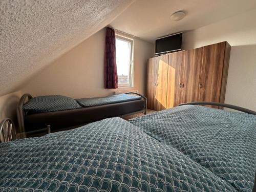 a bedroom with two twin beds and a window at Gästehaus Vienenburg - Monteurzimmer in Goslar
