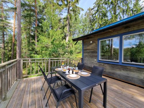 a wooden deck with a table and chairs on it at Forest Lodge Ryokan in Trosa