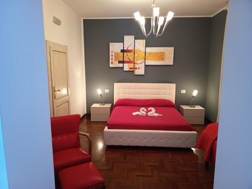 a bedroom with a red bed and a red chair at Setteacque Lakeview Rooms in Piediluco