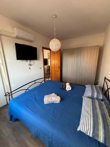 a blue bed with two towels and a stuffed animal on it at Dimora Vicky - La Ciaccia in Valledoria