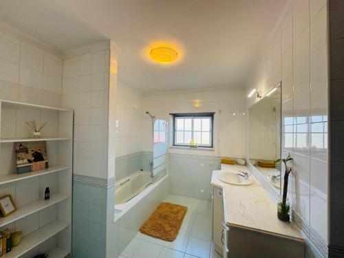 a bathroom with a tub and a sink and a shower at The Yellow Retreat in A dos Cunhados