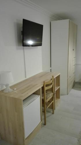a room with a desk with a television on a wall at Royaltybed Copenhagen in Copenhagen