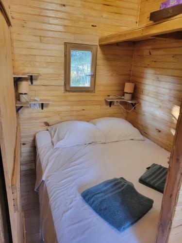 a bedroom with a bed in a wooden cabin at Roulotte à figeac in Figeac
