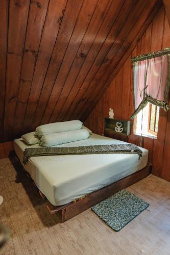 a bed in a room with a wooden wall at Balian Jus in Tuktuk Siadong