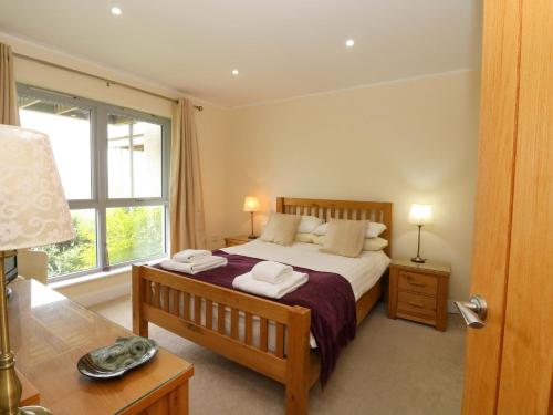 a bedroom with a large bed and a window at Craigard in Aberfeldy