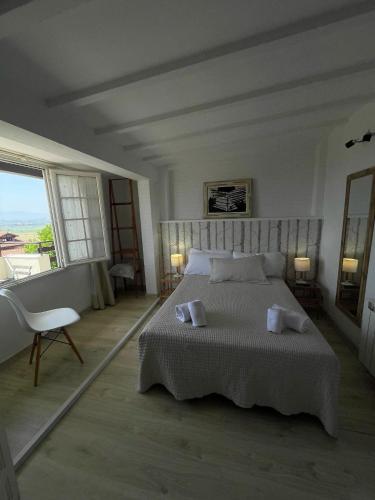 a bedroom with a large bed and a large window at CASA LAS OLAS DE LANGRE in Langre