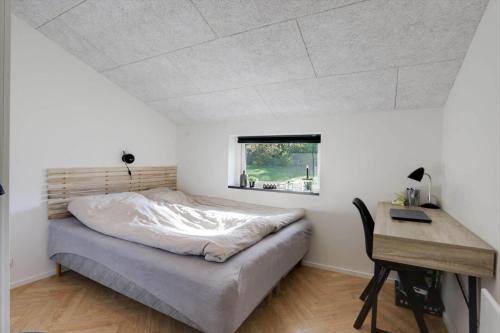 a bedroom with a bed and a desk and a window at JB415-Fjerritslev-Ahornvej-18 in Fjerritslev