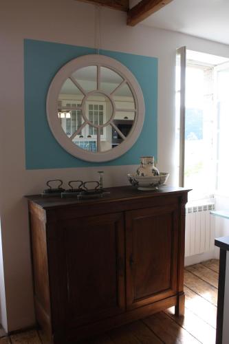 a mirror above a wooden cabinet in a room at Le Jardin Aux Lilas in Cadrieu