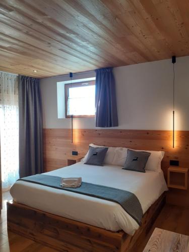 a bedroom with a large bed with a wooden ceiling at Affittacamere Sbulìa in Santo Stefano di Cadore