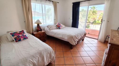 a bedroom with two beds and a large window at Beach Condo 7- Upper Floor near Balandra fast WiFi in La Paz