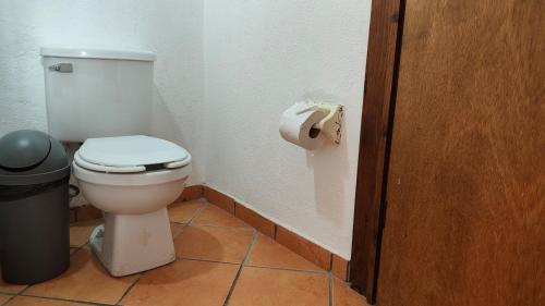 a bathroom with a toilet and a roll of toilet paper at Beach Condo 7- Upper Floor near Balandra fast WiFi in La Paz