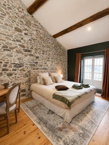 a bedroom with a large bed and a stone wall at Suite Sunan in Toulon