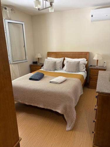 una camera da letto con un grande letto con due asciugamani sopra di Refúgio do mineiro a Arouca