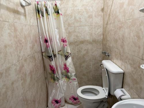 a bathroom with a toilet and a shower curtain with flowers at Casa del Arte in Salta