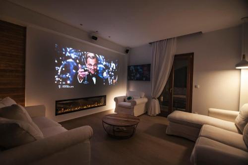 a living room with a large tv on the wall at Lithos House & Spa in Nafpaktos