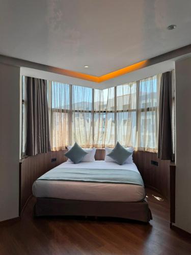 a bedroom with a large bed with large windows at Le M Neo in Rabat