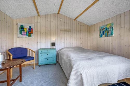 a bedroom with a bed and a table and a blue chair at C11267-Hemmet-Egernvej-12 in Henne Strand