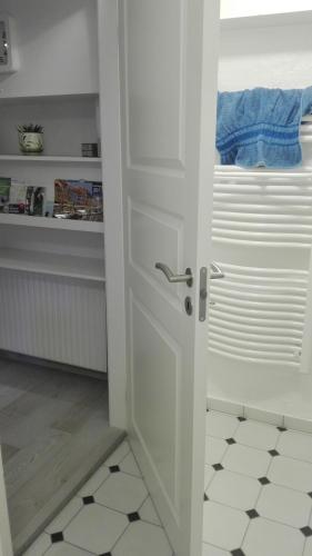 a white door in a kitchen with a tile floor at Royaltybed Copenhagen in Copenhagen