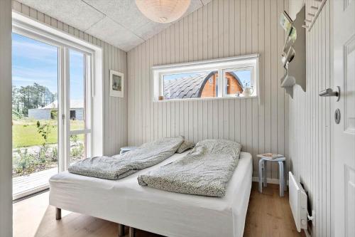 a bedroom with two beds and a window at 30454-Odder-Saksild-Strandfaelled-51 in Dyngby