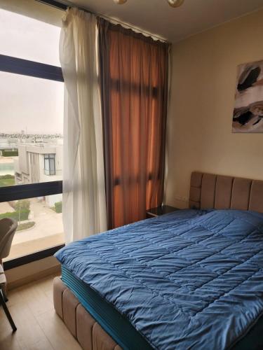 a bedroom with a bed and a large window at Azha Townhouse in Ain Sokhna