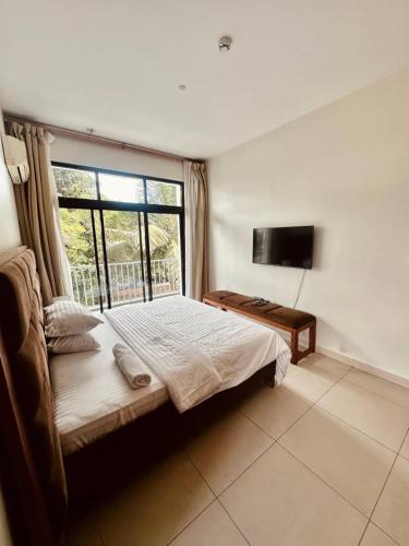 a bedroom with a bed and a large window at LUXIRIOUS Homes in Dar es Salaam