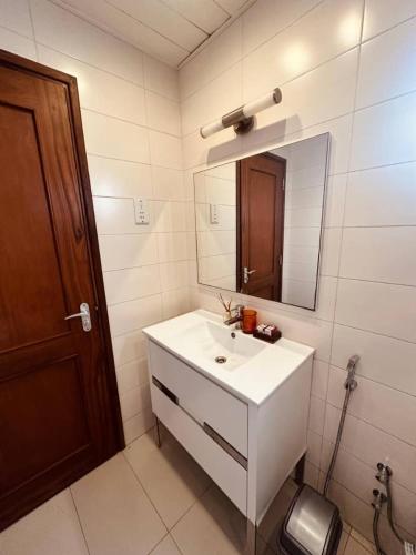 a bathroom with a white sink and a mirror at LUXIRIOUS Homes in Dar es Salaam