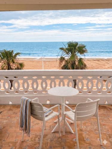 a patio with a table and two chairs and the ocean at Montserrat Casa del Mar in Chipiona