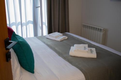 a bed with two towels sitting on top of it at Lake side Dilijan in Dilijan