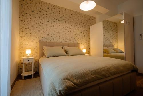 a bedroom with a large bed and a mirror at Apartman Lami in Krapina