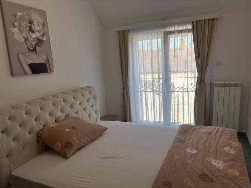 a bedroom with a bed with a pillow on it at Apartmani Rosa in Rača