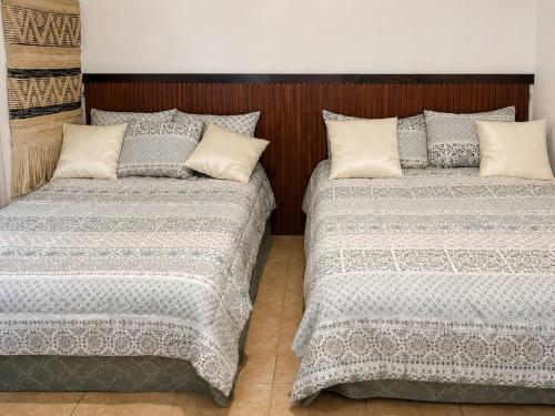 two beds sitting next to each other in a room at Los Flamboyanes Cozy Suite in Aguadilla