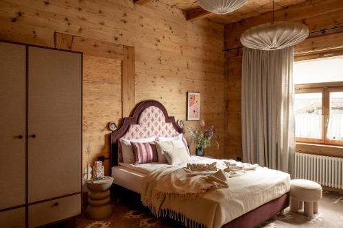 a bedroom with a pink bed and wooden walls at Owca na Polanie in Zakopane