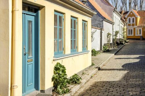 a yellow building with a blue door on a street at AE330-Aeroskobing-Ostergade-8 in Ærøskøbing
