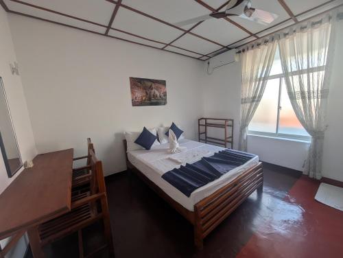 a bedroom with a large bed and a window at AmeriLanka Transit Hotel in Seeduwa