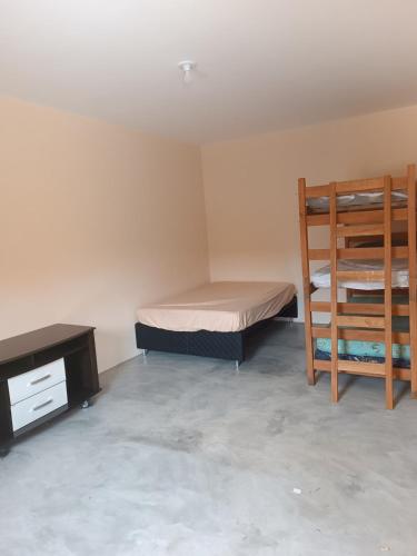 a room with two bunk beds and a desk at Casa com piscina e vista in São Pedro