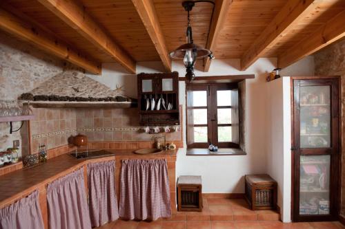 a kitchen with wooden ceilings and a sink and a window at Canary House With Heated Pool in Tuineje