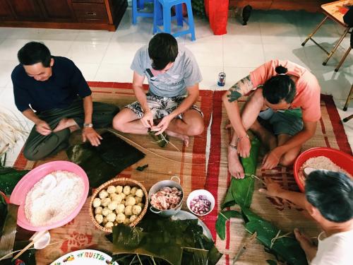 a group of men sitting on the floor with food at Vietnam Phuot Real Home in Kon Tum