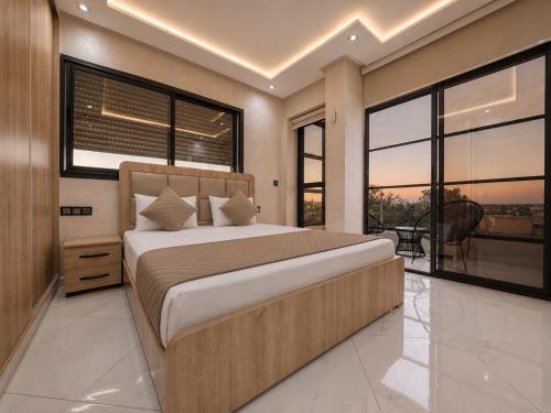a bedroom with a large bed and large windows at Royal Rif Alhoceima in Al Hoceïma