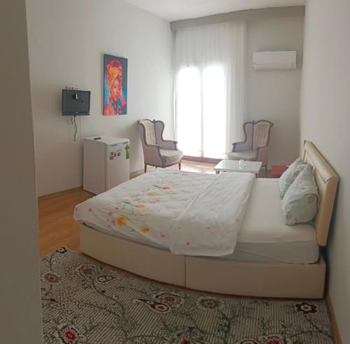 a bedroom with a bed and chairs in it at Yaşar otel in Mersin