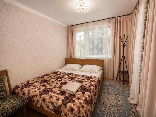 a bedroom with a bed and a window at Green yard Guest house Barskoon in Barskoon
