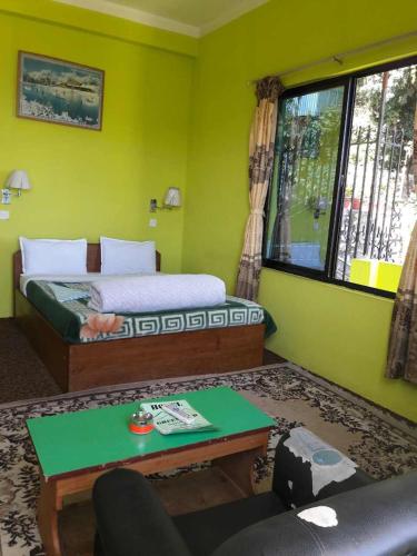 a room with a bed and a couch and a table at Hotel Greenland in Nagarkot
