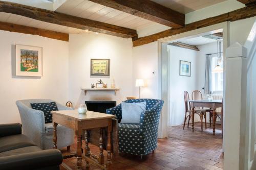 a living room with a couch and chairs and a table at Ferienwohnung Blücherkate I - Boldevitzer Rügenkaten in Parchtitz