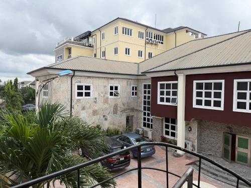 a building with cars parked in a parking lot at Vinpy hotels in Uyo