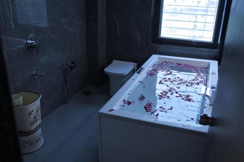 a bathroom with a bath tub covered in confetti at Hotel vs rooms in Ankleshwar