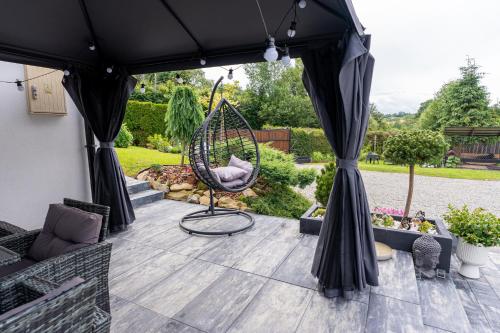 a patio with a hammock and a swing at Bieszczady Hill - Dolna in Czarna