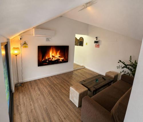 a living room with a couch and a fireplace at Wood Nest in Bragadiru