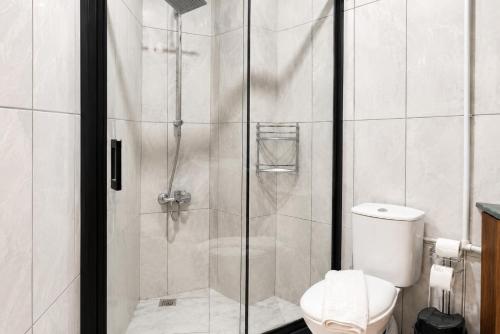 a bathroom with a shower with a toilet at New Green Airport Hotel & Restaurant in Arnavutköy