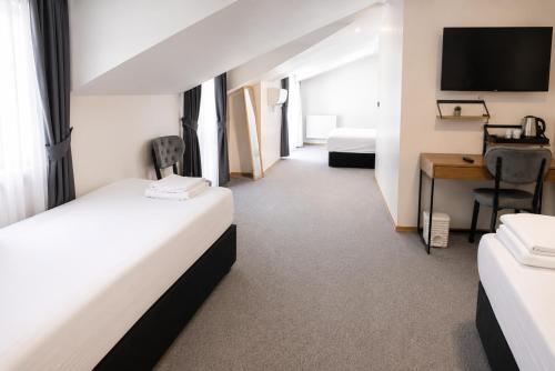 a hotel room with two beds and a desk at New Green Airport Hotel & Restaurant in Arnavutköy