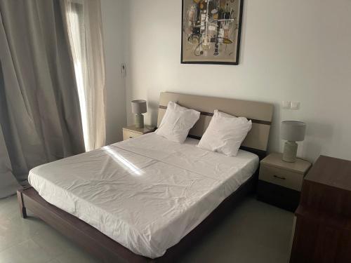 a bedroom with a bed with white sheets and pillows at Rubis2 appart C2 in Ngaparou